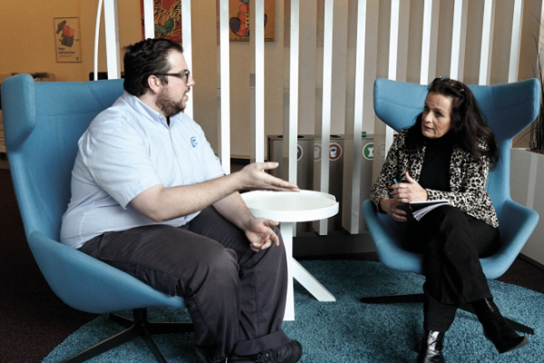 Twee mensen in gesprek in een zithoek